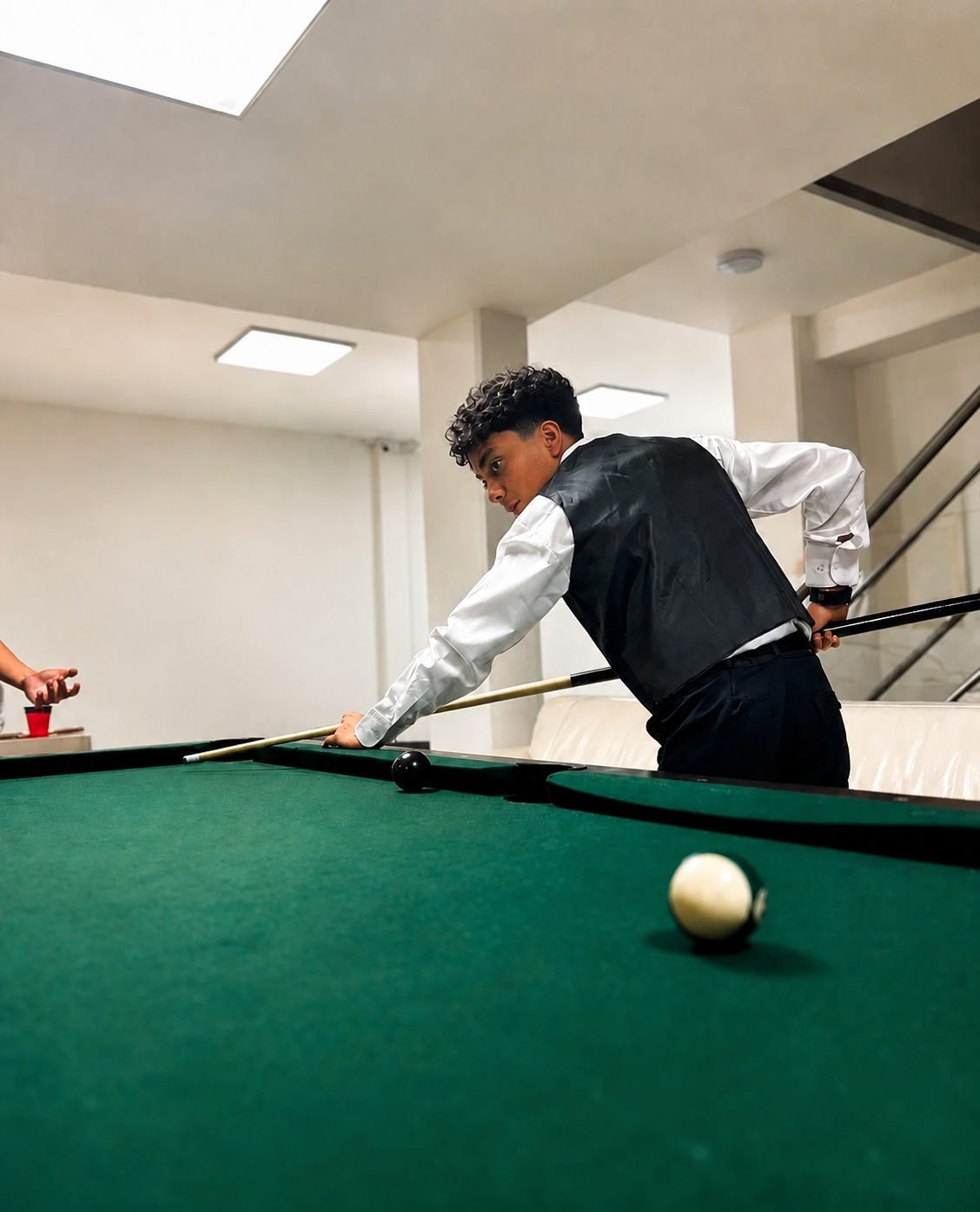 Un joven jugando billar en la zona recreativa de la planta baja del salón
