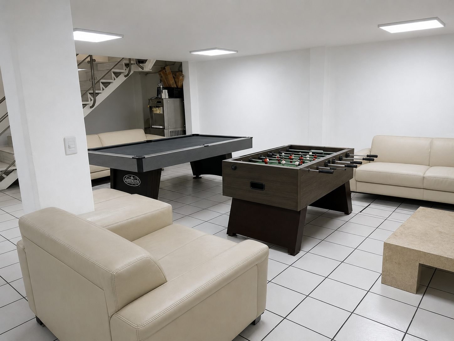 Futbolito y mesa de billar junto a los sillones de la zona recreativa